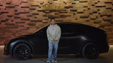 Paul Rodriguez con un Tesla detrás y las letras de Primitive Skateboarding al fondo.