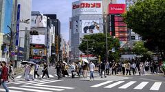 People cross a street during the &quot;golden week&quot; holiday in Tokyo&#039;s Shinjuku area on May 5, 2022. (Photo by Charly TRIBALLEAU / AFP)