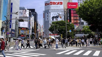 People cross a street during the "golden week" holiday in Tokyo's Shinjuku area on May 5, 2022. (Photo by Charly TRIBALLEAU / AFP)