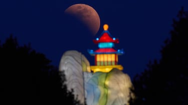 La Luna se ve poco antes del eclipse total cerca de una linterna en Beijing.
