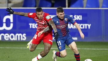 HUESCA, SPAIN - FEBRUARY 21: Javi Galan of SD Huesca battles for possession with Kenedy of Granada CF during the La Liga Santander match between SD Huesca and Granada CF at Estadio El Alcoraz on February 21, 2021 in Huesca, Spain. Sporting stadiums around