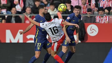 (From L) Atletico Madrid's Slovak defender #17 David Hancko, Girona's Spanish defender #16 Alejandro Frances and Atletico Madrid's Italian defender #03 Matteo Ruggeri fight for the ball during the Spanish league football match between Girona FC and Club Atletico de Madrid at Montilivi Stadium in Girona on December 21, 2025. (Photo by MANAURE QUINTERO / AFP)