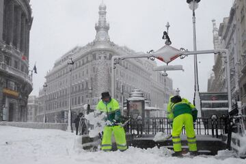 Operarios trabajan para retirar nieve y mejorar la circulación en la Puerta del Sol en Madrid.