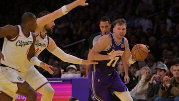 Nov 25, 2025; Los Angeles, California, USA; Los Angeles Lakers guard Luka Doncic (77) drives past Los Angeles Clippers guard Kris Dunn (8) and center Ivica Zubac (40) during the first half at Crypto.com Arena. Mandatory Credit: Jayne Kamin-Oncea-Imagn Images