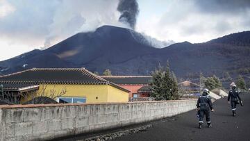In this handout photograph taken on November 19, 2021 and released by the Spanish Military Emergency Unit (UME) on November 20, members of the UME monitor gas emissions in an ash-covered area of Las Manchas, following the eruption of the Cumbre Vieja volc