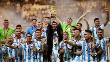 Lionel Messi celebrates with the trophy and teammates after winning the World Cup.