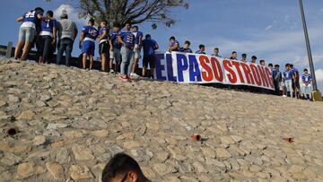 Members of the Americas High School football team from El Paso carry an "El Paso Strong" sign into place near the site of a mass shooting over the weekend at a shopping complex, Monday, Aug. 5, 2019, in El Paso, Texas. (AP Photo/John Locher)