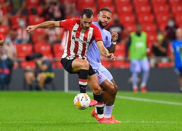 Memphis Depay trata de quitarle el balón a Iñigo Lekue.