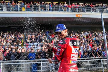 Pecco Bagnaia lanza prosecco al público tras ganar la carrera al esprint del Gran Premio de Barcelona Solidaridad de MotoGP.