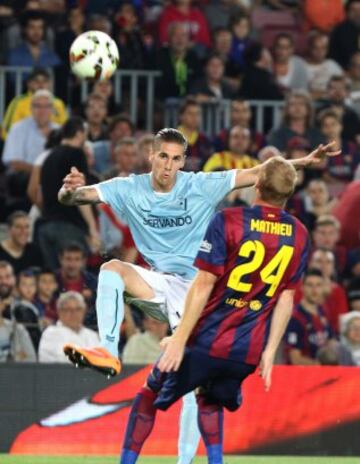 El defensa francés del barcelona Jeremy Mathieu (d) pelea un balón con el defensa del Eibar Raúl Albentosa.