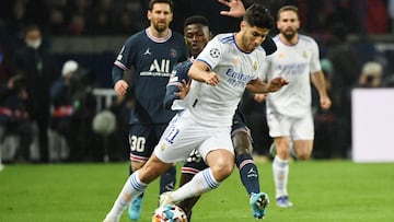 Real Madrid's Spanish midfielder Marco Asensio (R) fights for the ball with Paris Saint-Germain's Portuguese defender Nuno Mendes (L) during the UEFA Champions League round of 16 first leg football match between Paris Saint-Germain (PSG) and Real Madrid at the Parc des Princes stadium in Paris on February 15, 2022. (Photo by Alain JOCARD / AFP)