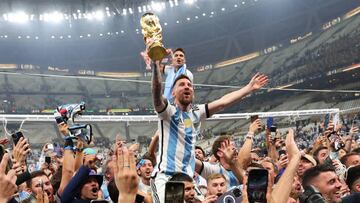 LUSAIL CITY, QATAR - DECEMBER 18: Lionel Messi of Argentina celebrates on Sergio Aguero of Argentina's shoulders with the FIFA World Cup Trophy following his team's victory in during the FIFA World Cup Qatar 2022 Final match between Argentina and France at Lusail Stadium on December 18, 2022 in Lusail City, Qatar. (Photo by Marc Atkins/Getty Images)