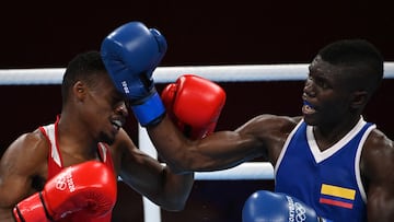 Botswana's Rajab Otukile Mahommed (red) and Colombia's Yuberjen Herney Martinez Rivas fight during their men's fly (48-52kg) preliminaries boxing match during the Tokyo 2020 Olympic Games at the Kokugikan Arena in Tokyo on July 26, 2021. (Photo by Luis ROBAYO / AFP)