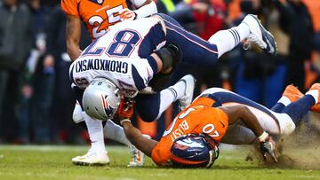 Jan 24, 2016; Denver, CO, USA; New England Patriots tight end Rob Gronkowski (87) catches a pass and is tackled by Denver Broncos free safety Josh Bush (20) and cornerback Chris Harris (25) in the fourth quarter in the AFC Championship football game at Sports Authority Field at Mile High. Mandatory Credit: Mark J. Rebilas-USA TODAY Sports