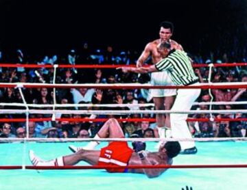 30 de Octubre de 1974. George Foreman, vigente campeón del mundo y Muhammad Ali, aspirante y apartado dos años del boxeo, libraron el 'último combate del siglo' en Kinshasa (entonces Zaire y hoy Congo). En la imágen el arbitro Zack Clayton lleva a la esquina al aspirante tras noquear al campeón en el octavo asalto. 