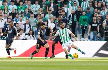 EL jugador del Real Madrid, Brahim Díaz, persigue al jugador del Betis, Isco, que trata de controlar el balón.  
 
