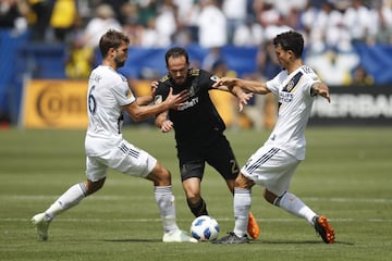 Jorgen Skjelvik, Marco Ureña y Servando Carrasco pelean por un balón en el primer derbi angelino.