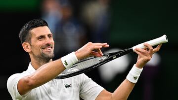 Serbia's Novak Djokovic pretends to play the violin for his daughter as he celebrates winning against Denmark's Holger Rune during their men's singles tennis match on the eighth day of the 2024 Wimbledon Championships at The All England Lawn Tennis and Croquet Club in Wimbledon, southwest London, on July 8, 2024. (Photo by ANDREJ ISAKOVIC / AFP) / RESTRICTED TO EDITORIAL USE