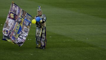 A fan dressed with the colors of Argentina's Boca Juniors walks on the pitch of the Bombonera stadium during a team training session in Buenos Aires, Argentina Thursday, Nov. 22, 2018. Boca Juniors faces River Plate for the Copa Libertadores soccer final game on Saturday.(AP Photo/Natacha Pisarenko)