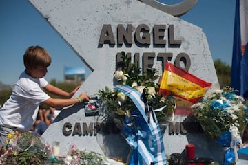 A boy adds a photograph on a tribute monument to Angel Nieto at Jerez racetrack today.