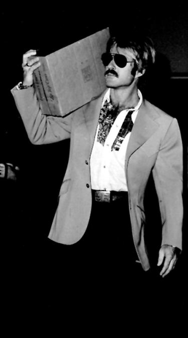 El actor estadounidense Robert Redford en el aeropuerto londinense de Heathrow, antes de partir hacia Chicago tras una visita a la ciudad, con una caja de cerveza australiana en 1976.   