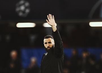 El delantero francés del Real Madrid, Karim Benzema, saluda a los aficionados del club blanco presentes en Stamford Bridge tras el pitido final.