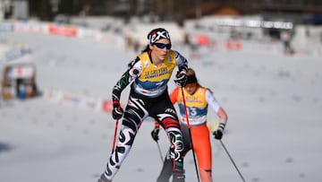 Imagen de Regina Martínez, esquiadora mexicana, con uniforme amarillo y negro con letras en blanco, poles en rojos y negros en sus manos, esquiando sobre la nieve.