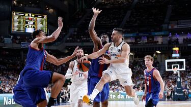 Facundo Campazzo, base del Madrid, trata de pasar ante la defensa de Oscar da Silva y James Nnaji, del Barcelona.