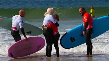 Dos competidoras se abrazan, con las licras de competici&oacute;n y una ola al fondo en la playa de Patos (Nigr&aacute;n, Galicia), durante el Campeonato de Espa&ntilde;a de surf adaptado 2021, celebrado el 26 de septiembre del 2021. 