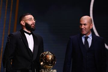 El delantero francés del Real Madrid, Karim Benzema, recibe el Balón de Oro de manos del ex futbolista francés Zinedine Zidane.