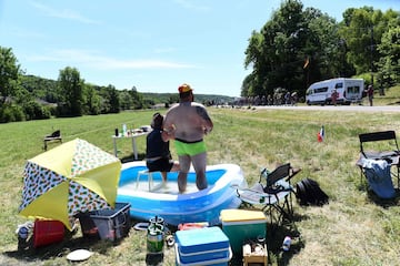 Dos espectadores se refrescan en una piscina mientras observan el paso de la carrera ciclista del Tour de Francia entre Reims y Nancy, el 9 de julio de 2019. 