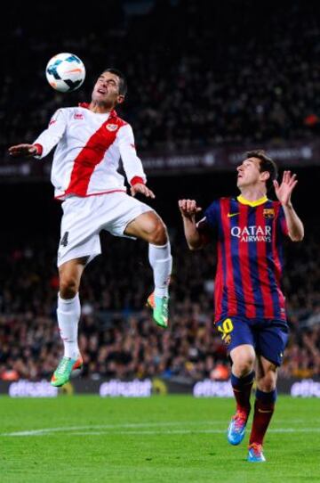 Lionel Messi del FC Barcelona pelea por el balón con Iago Falque del Rayo Vallecano