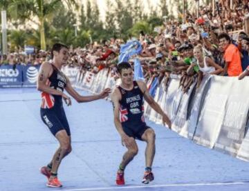 Alistair Brownlee ayuda a su hermano Jonathan que cae al cruzar la meta.