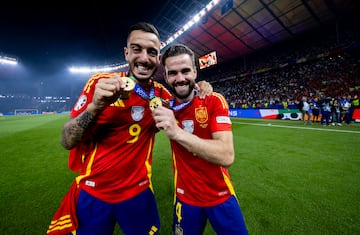 Joselu y Nacho Fernández, muestran sus medallas que les acreditan campeones de la Eurocopa.