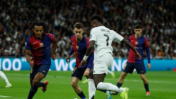 MADRID, 26/10/2024.- El delantero brasileño del Real Madrid Vinícius Júnior (d) disputa un balón ante Jules Koundé (i) y Marc Casadó del FC Barcelona, durante el partido de la jornada 11 de LaLiga EA Sports entre el Real Madrid y el FC Barcelona, este sábado en el estadio Santiago Bernabéu, en Madrid. EFE/ Juanjo Martín