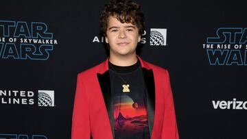 El famoso actor de 'Stranger Things' llegó a la alfombra con una playera negra y un blazer rojo.