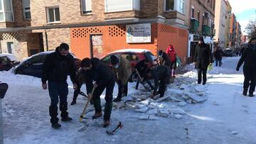 Aficionados del Rayo y vecinos de Vallecas quitan la nieve del barrio.