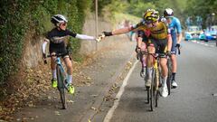 El ciclista del Jumbo-Visma Pascal Eenkhorn le entrega un bid&oacute;n al joven ciclista Xander Graham durante la s&eacute;ptima etapa del Tour of Britain, el Tour de Gran Breta&ntilde;a.