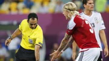 El jugador de Alemania Thomas Mueller (c) se lamenta en el suelo mientras Simon Kjaer (d) de Dinamarca discute con el árbitro español Carlos Velasco (i) durante el partido que les enfrenta hoy, domingo 17 de junio de 2012, por el grupo B de la Eurocopa 2012 en Lviv, Ucrania.