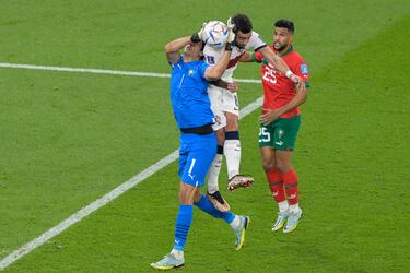 El jugador portugués Bruno Fernandes entra con fuerza ante el portero marroquí Yassine Bounou. 
