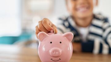 Ni&ntilde;o metiendo dinero a una alcanc&iacute;a v&iacute;a Getty Images.