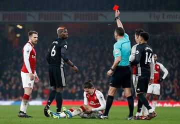 Referee Andre Marriner shows a red card to Manchester United's French midfielder Paul Pogba for his challenge on Arsenal's Spanish defender Hector Bellerin.