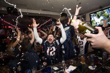 Los aficionados de los Patriots se reunieron en bares para ver el partido mientras comían alitas y bebían cervezas. En la imagen seguidores celebran el final del partido.