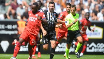 Lyon's French forward Moussa Dembele (L) fights for the ball with Angers' French midfielder Thomas Mangani (C) during the French L1 football match between Angers SCO and Olympique Lyonnais, at the Raymond-Kopa Stadium, in Angers, western France