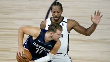Los Angeles Clippers' Kawhi Leonard, right, applies pressure on Dallas Mavericks' Luka Doncic (77) during the second half of an NBA basketball game Thursday, Aug. 6, 2020 in Lake Buena Vista, Fla. (AP Photo/Ashley Landis, Pool)