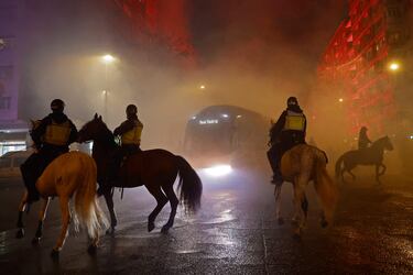 Bufandas al aire, el humo de las bengalas y el autobús del Real Madrid y el del Atlético avanzan entre la niebla... Las aficiones recibieron de esta manera a sus  equipos.
