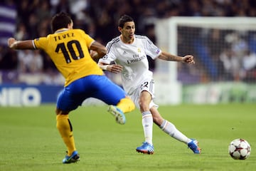 Real Madrid's Argentinian midfielder Angel di Maria (R) vies with Juventus' Argentinian forward Carlos Alberto Tevez during the UEFA Champions League Group B football match Real Madrid CF vs Juventus at the Santiago Bernabeu stadium in Madrid on October 23, 2013.   AFP PHOTO/ JAVIER SORIANO