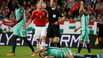 Soccer Football - 2018 World Cup Qualifications - Europe - Hungary vs Portugal - Budapest, Hungary - September 3, 2017   Referee Danny Makkelie gestures with a red card in his hand as Portugal&rsquo;s Pepe lies on the floor   REUTERS/Laszlo Balogh