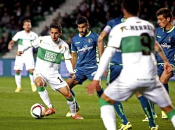 El delantero del Elche Ferrán Corominas (i) con el balón ante varios jugadores del Real Valladolid, durante el partido de vuelta de dieciseisavos de final de la Copa del Rey, disputado esta tarde en el estadio Martínez Valero. 