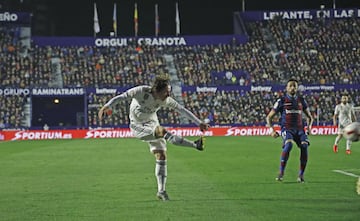 Modric intenta dar el pase al área y el jugador del Levante, Bardhi, para el balón con la mano.  